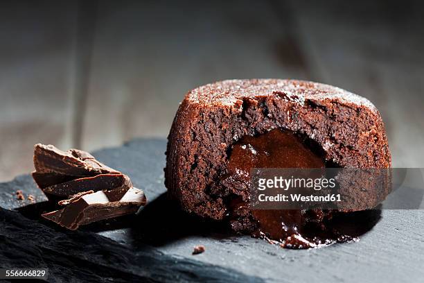 sliced small chocolate tart with melted chocolate filling on slate - チョコレートケーキ ストックフォトと画像