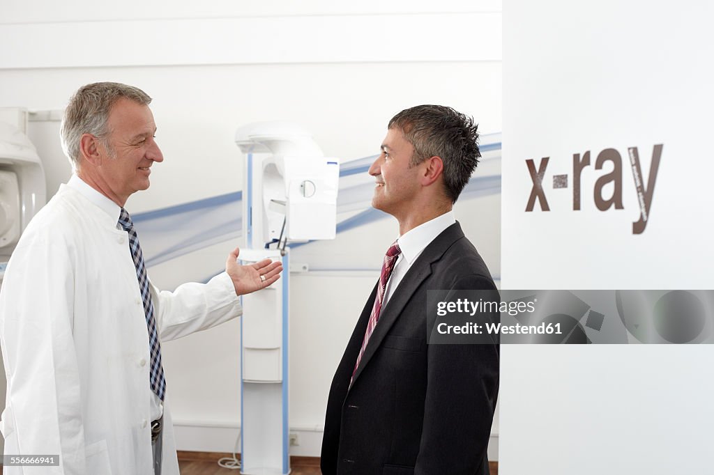 Doctor in hospital preparing Cone-Beam CT examination for patient