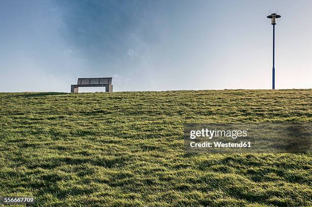 germany, neuharlingersiel, empty bench on dike - deich stock-fotos und bilder