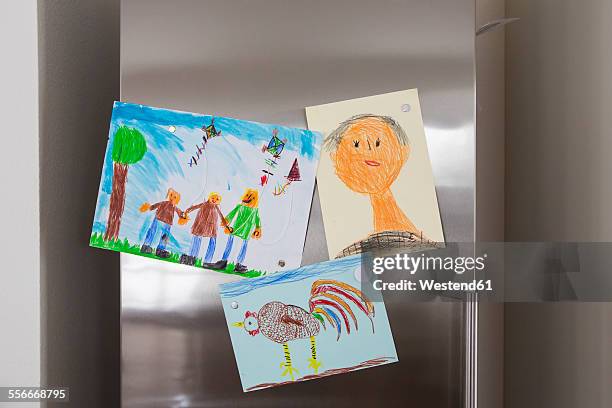 child's drawings fixed at fridge - magnet drawing stock pictures, royalty-free photos & images