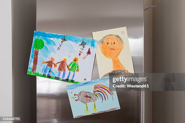 child's drawings fixed at fridge - child's drawing stock pictures, royalty-free photos & images