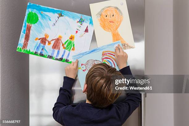 boy fixed his drawings at fridge - kids art stock pictures, royalty-free photos & images