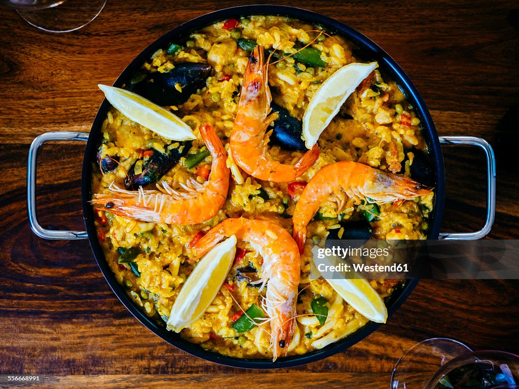 Fresh paella in pan on wooden table