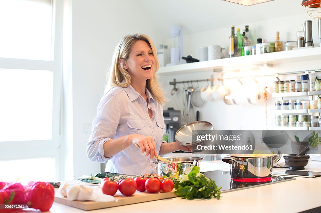 Happy woman cooking in kitchen