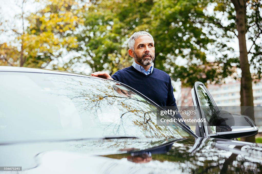 Man standing beside his car