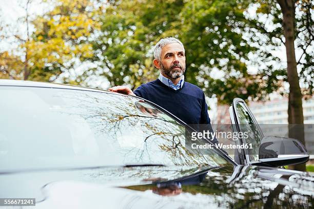 man standing beside his car - entering stock pictures, royalty-free photos & images