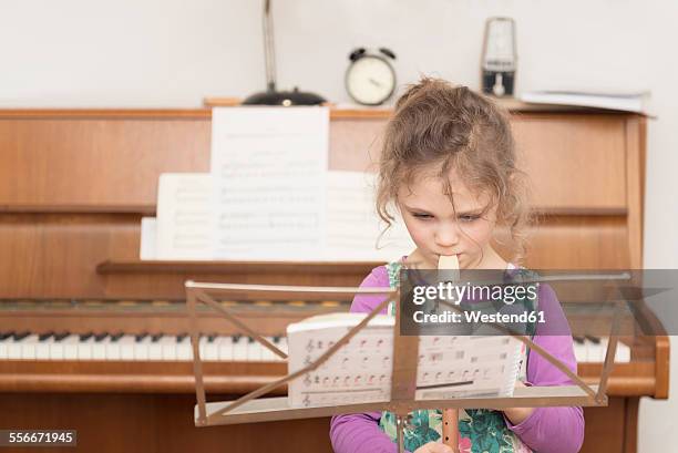 girl at music stand playing recorder - blockflöte stock-fotos und bilder