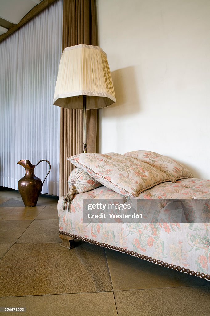 Old-fashioned couch and floor lamp in a living room