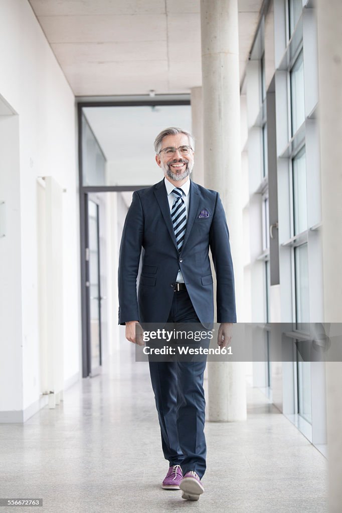 Confident businessman walking on hallway