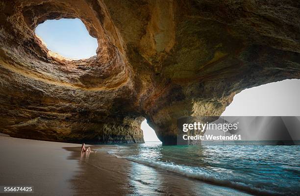 portugal, beach of benagil, cave, woman sitting at seafront - algarve stock pictures, royalty-free photos & images