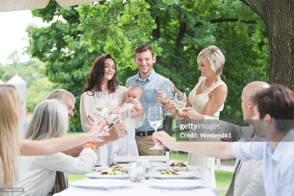 Baby being introduced to family on a garden party