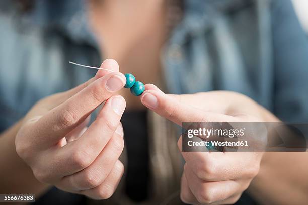 close-up of woman stringing beads to create a necklace - bead bildbanksfoton och bilder