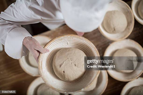 female baker preparing ceramic bowls for baking bread - baker smelling bread stock pictures, royalty-free photos & images