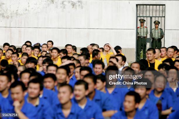 Inmates watch an entertainment show to mark the upcoming Mid-autumn Festival, a traditional Chinese festival for family reunion, as police guard at a...