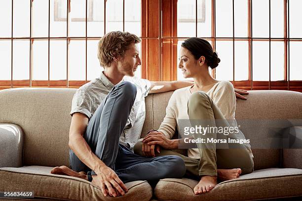 loving couple siting on sofa at home - straight bildbanksfoton och bilder