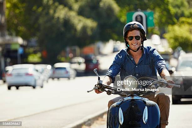 happy man riding motorcycle on sunny day - homens de idade mediana - fotografias e filmes do acervo