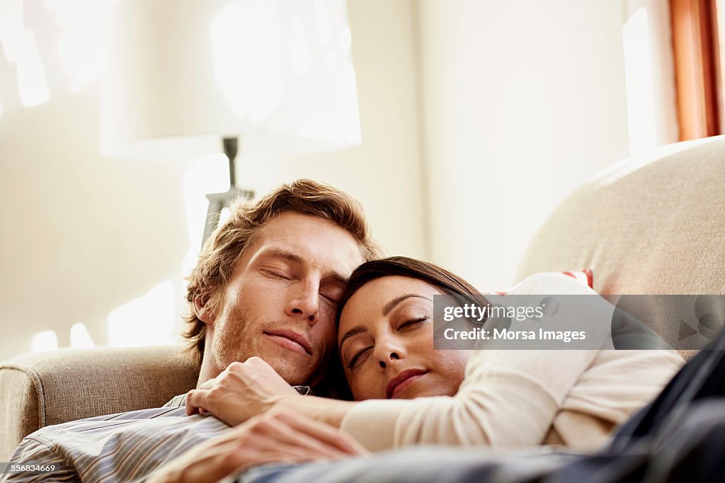 Loving couple sleeping on sofa