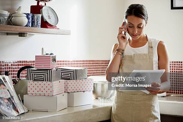 woman working in kitchen - red telephone box photos et images de collection