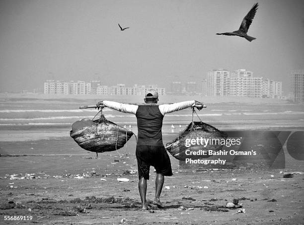 fisherman holding his bucket - clifton beach pakistan stock pictures, royalty-free photos & images