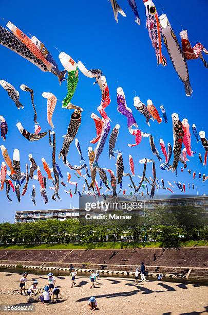 children under the many carp banners - koinobori stock pictures, royalty-free photos & images