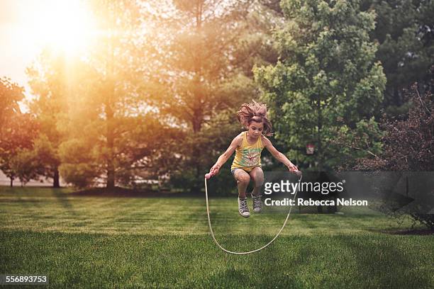 girl, caught mid air, jumping rope - girl jumping stock-fotos und bilder