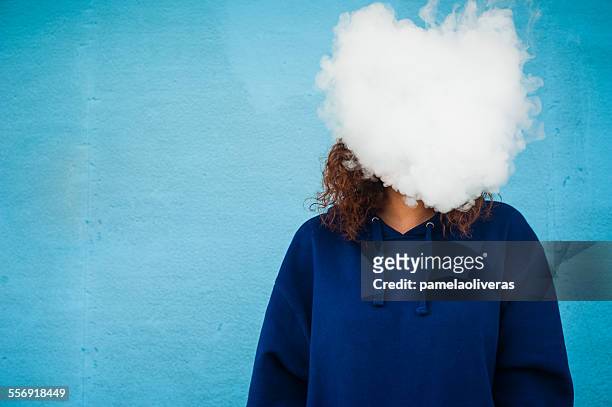 young woman with her head in a cloud of vapor smoke - 電子タバコ ストックフォトと画像