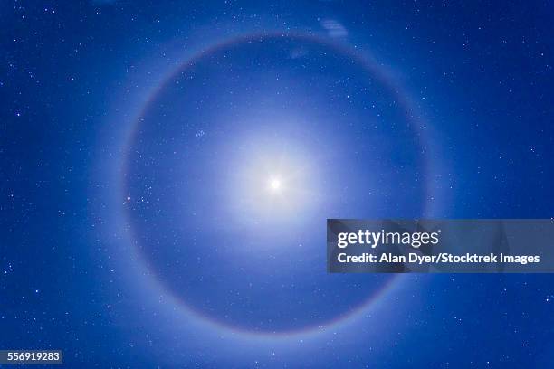 an ice crystal halo around the first quarter moon. - optical phenomenon halo stock pictures, royalty-free photos & images