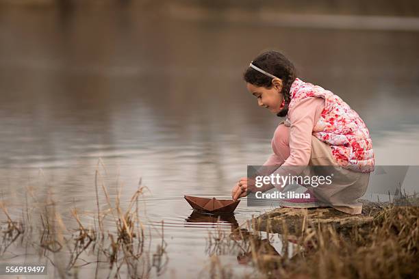 young girl playing with a paper boat - paper boat stock pictures, royalty-free photos & images