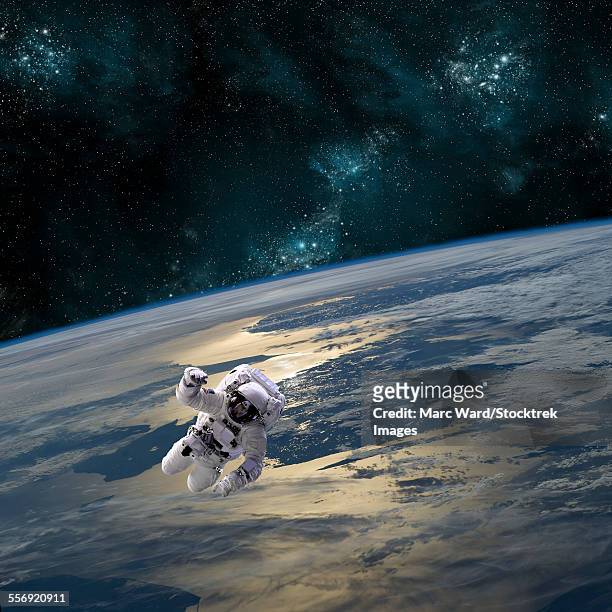 an astronaut floating above earth. - spacewalk stock-fotos und bilder