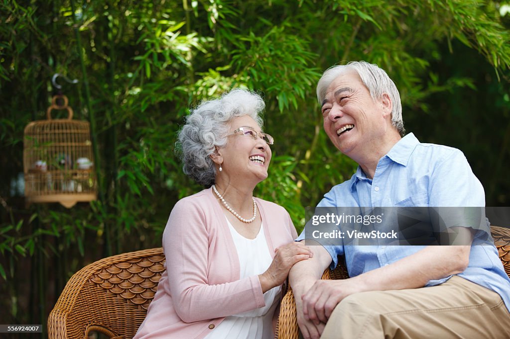 The old couple sitting on a chair in the garden
