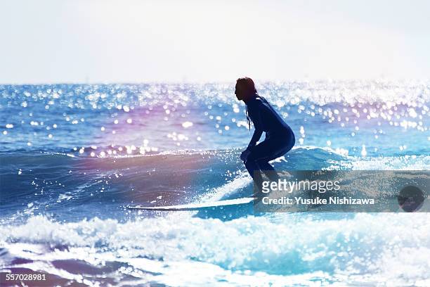 female surfer riding the wave - deporte acuático fotografías e imágenes de stock