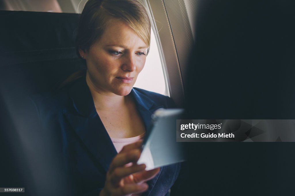 Woman using tablet pc in plane.