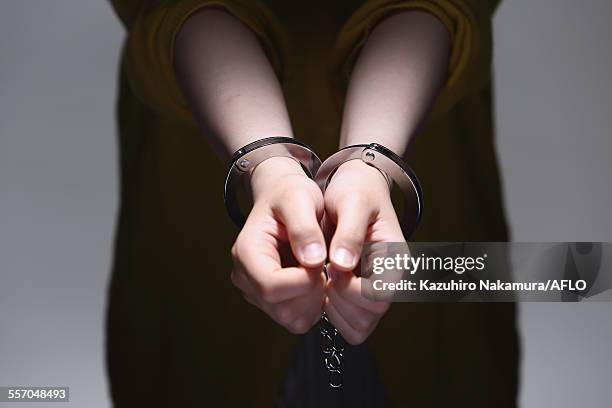 handcuffed arms - handcuffs photos et images de collection