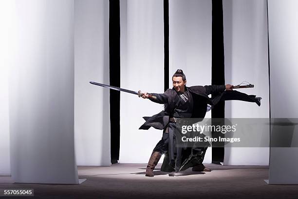 man practicing martial arts in ancient costumes - chinese martial arts stock pictures, royalty-free photos & images