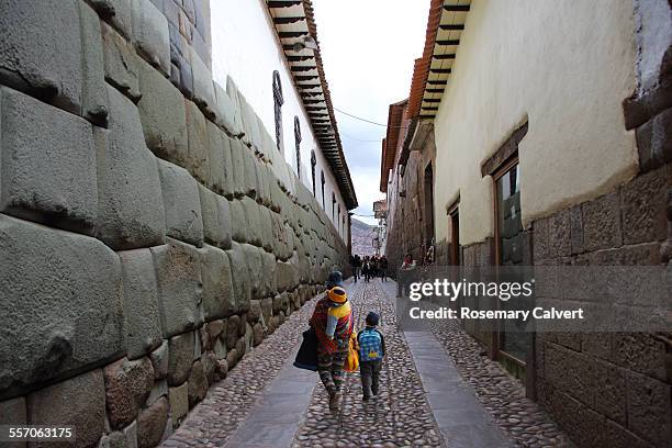 street with inca wall & peruvian family,cusco,peru - dreiviertel rückansicht stock-fotos und bilder