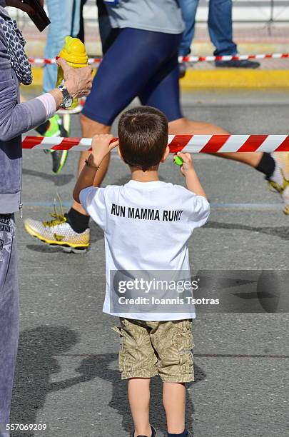 kid waiting for his mother during a marathon - marathon zuschauer stock-fotos und bilder