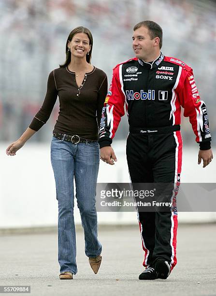 Ryan Newman, driver of the Alltel Dodge, walks with his wife Krissie during qualifying for the NASCAR Nextel Cup Sylvania 300 on September 17, 2005...