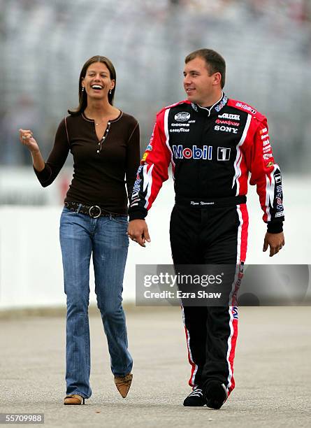 Ryan Newman, driver of the Mobil 1/Alltel Dodge, walks with his wife Krissie during qualifying for the NASCAR Nextel Cup Sylvania 300 on September...