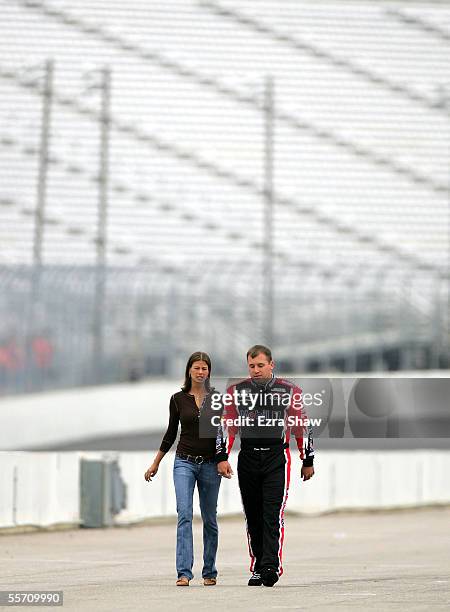 Ryan Newman, driver of the Mobil 1/Alltel Dodge, walks with his wife Krissie during qualifying for the NASCAR Nextel Cup Sylvania 300 on September...