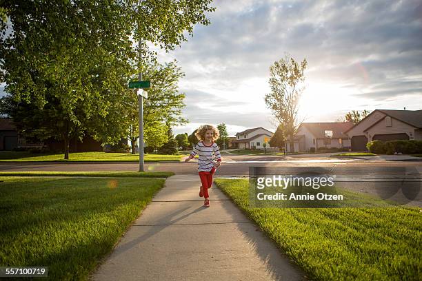 little girl running - suburbio zona residencial fotografías e imágenes de stock