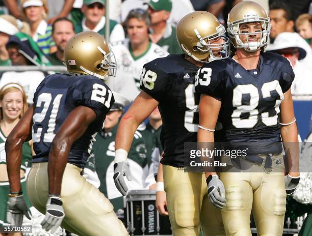 Wide receiver Jeff Samardzija of the Notre Dame Fighting Irish stands in the end zone after scoring a touchdown as teammates Anthony Fasano and...