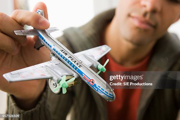 man holding toy airplane - sie productions foto e immagini stock