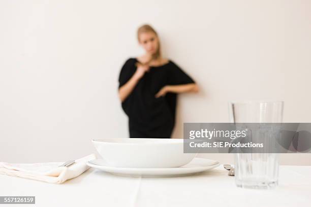 woman standing by place setting - sie productions foto e immagini stock