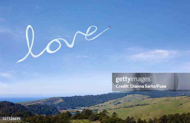 airplane skywriting love - skywriting stock pictures, royalty-free photos & images