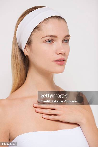 beautiful woman applying moisturizer - decolleté stockfoto's en -beelden