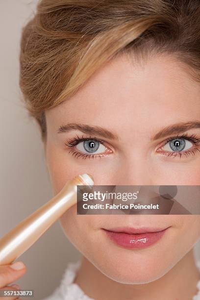 portrait of a beautiful woman applying concealer - concealer stock pictures, royalty-free photos & images
