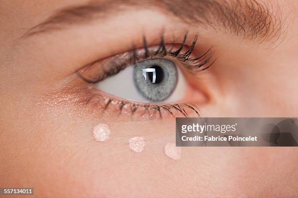 beautiful woman applying concealer - concealer stock pictures, royalty-free photos & images
