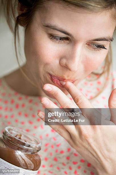 woman eating a chocolate - genuss stock-fotos und bilder