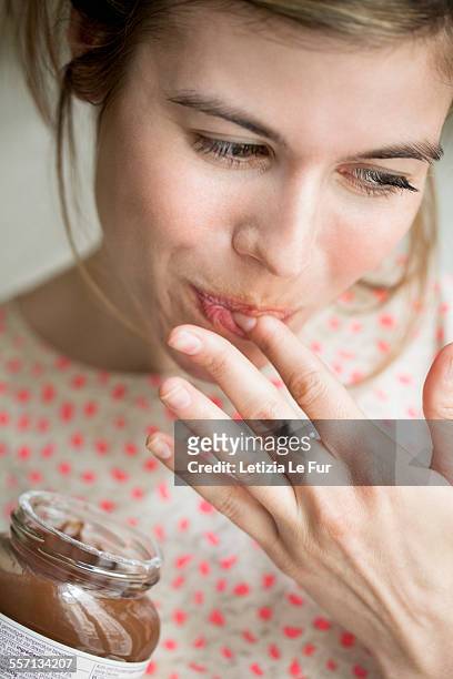 woman eating a chocolate - indulgence foto e immagini stock