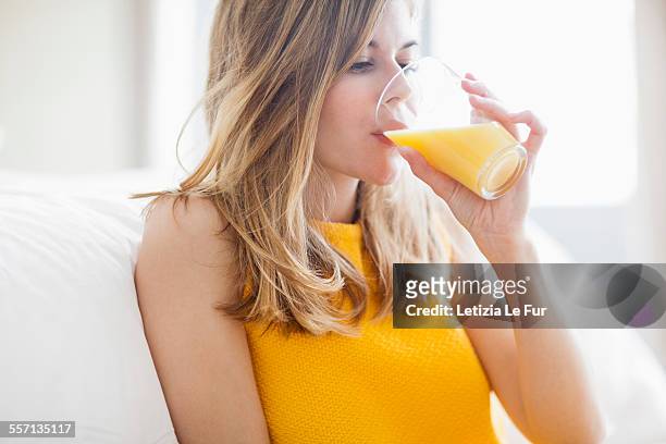 woman drinking orange juice - orange juice stock-fotos und bilder